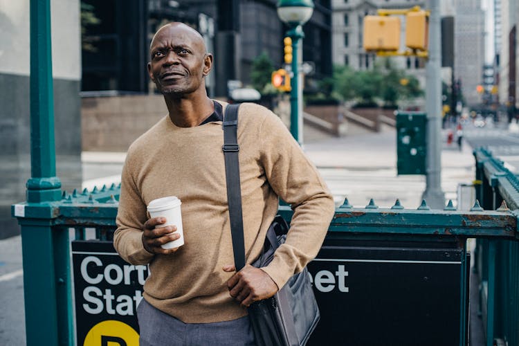 Mature Man With Coffee At Subway Entrance