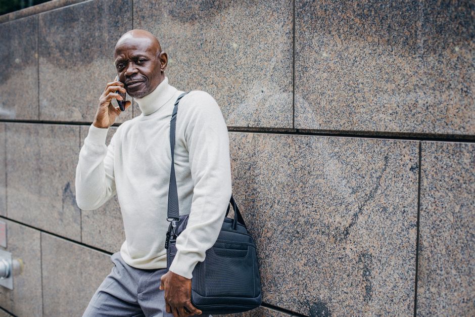 A distressed worker on a cellphone outside a shuttered business, looking defeated