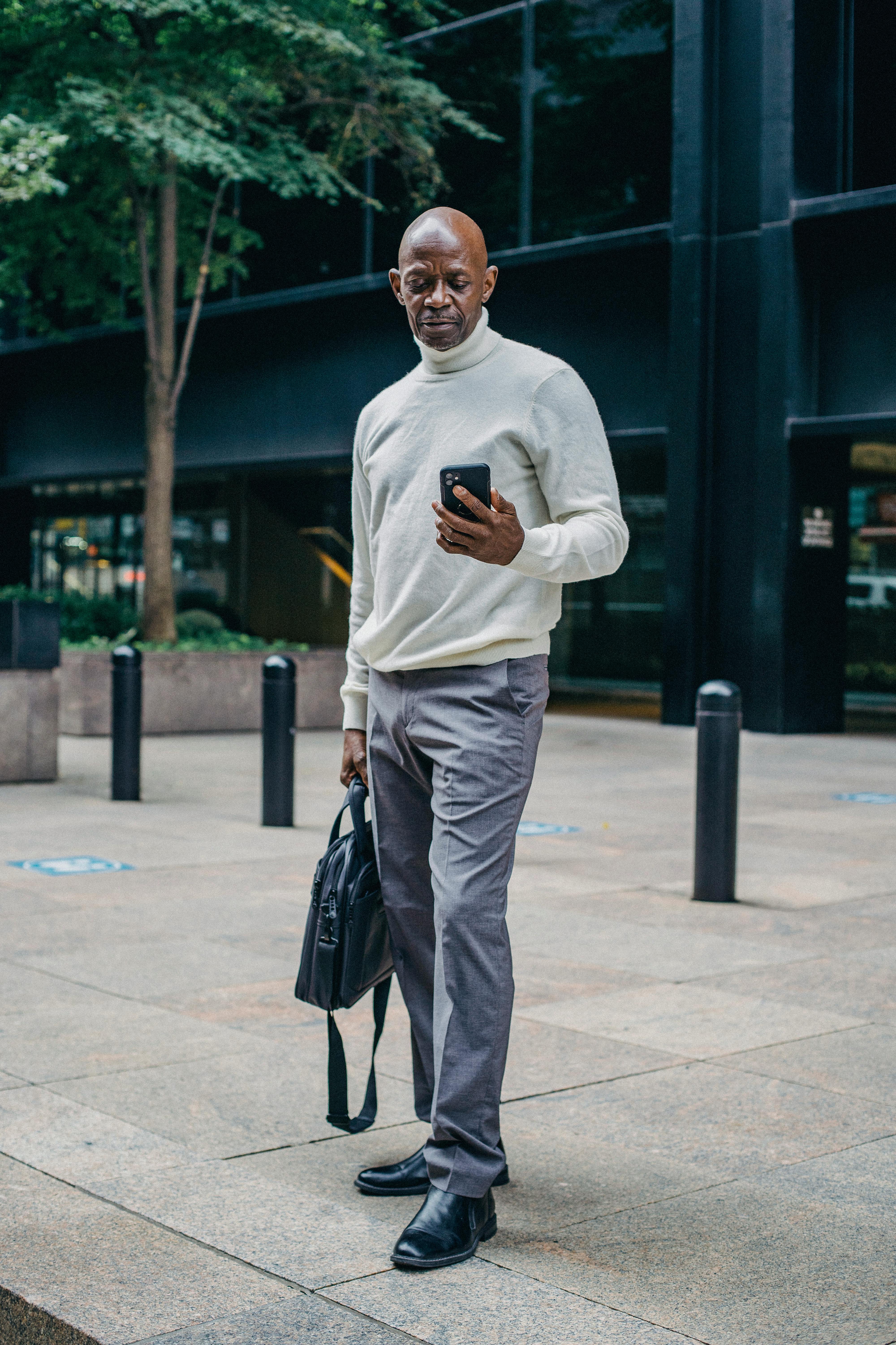 busy black man with smartphone on street