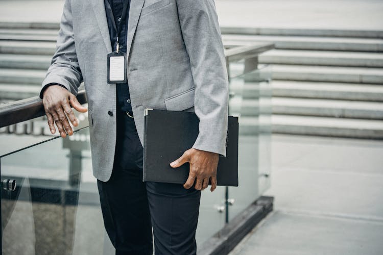 Faceless Black Businessman Carrying Paper Case