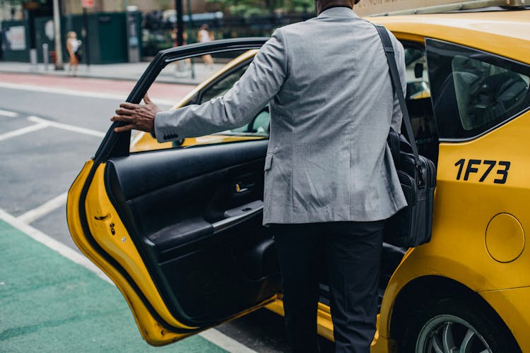 Crop Faceless Black Man Opening Door Of Taxi