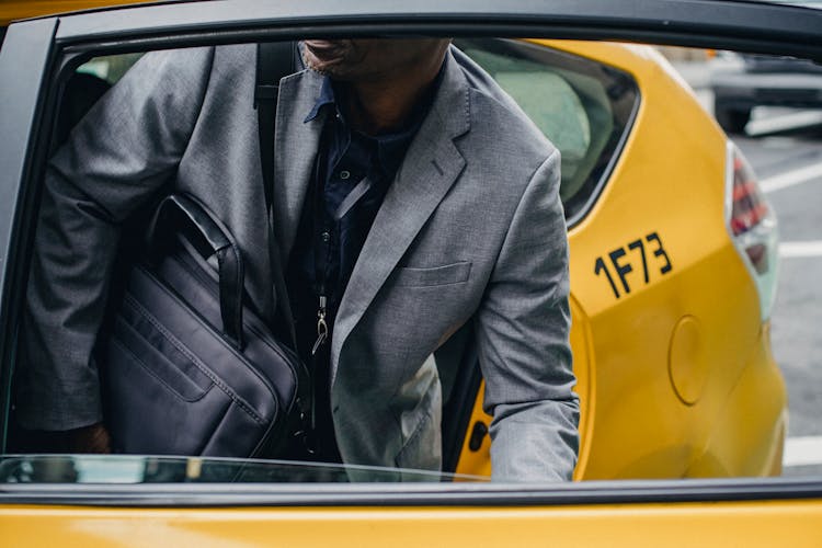 Crop Faceless Black Man Sitting In Cab And Closing Door