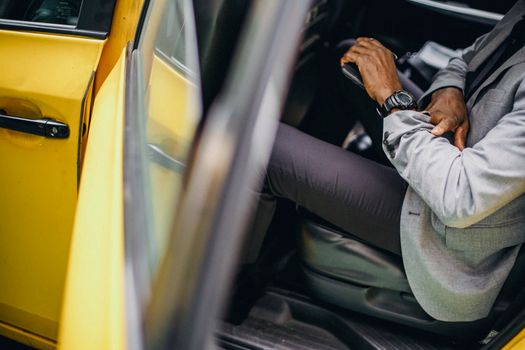 Side view of crop anonymous African American male in elegant suit checking wristwatch in car