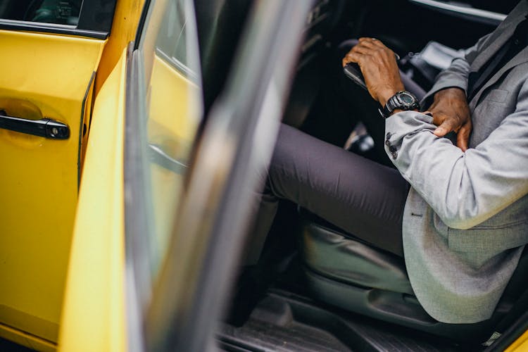 Black Businessman With Wristwatch In Yellow Automobile