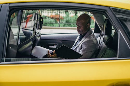 車の中で重要なレポートを調べる物思いにふける黒人起業家