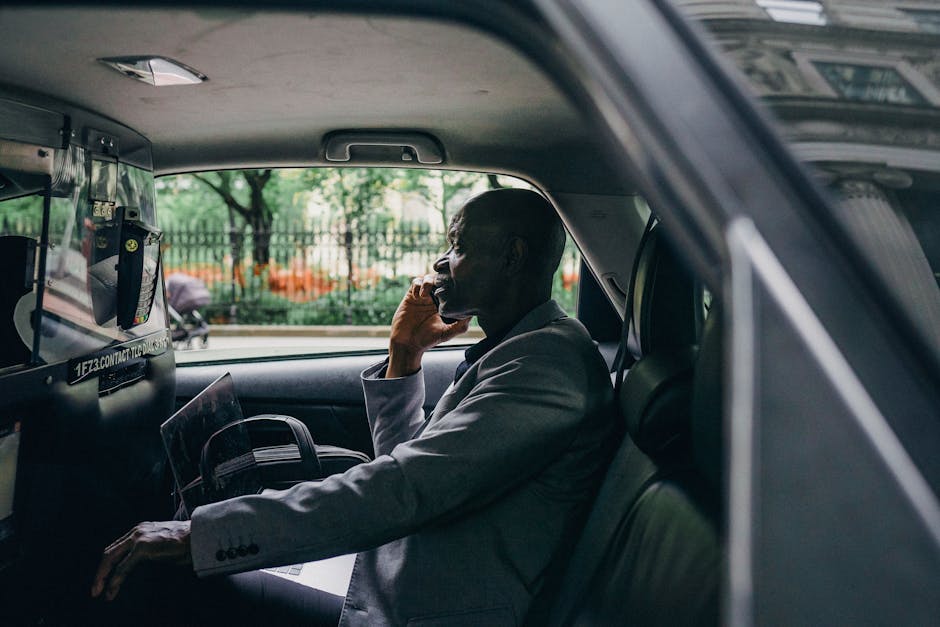 Side view of African American male discussing strategy on mobile phone in automobile