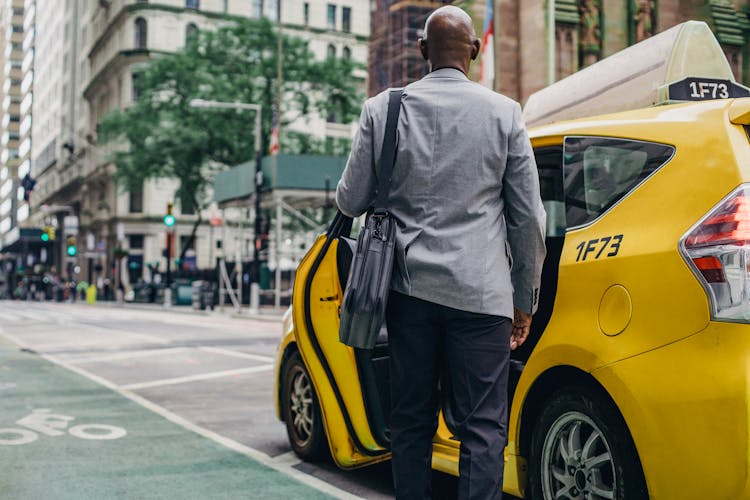 Black Man In Stylish Suit Near Taxi