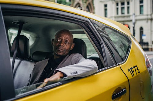 Middle aged African American male in business suit looking away while going by taxi