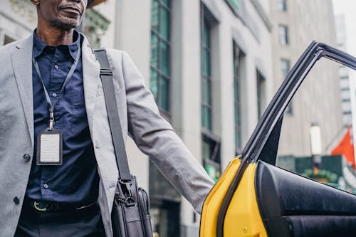 Mature black man opening door of yellow cab