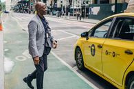 Black stylish man going to taxi on asphalt road