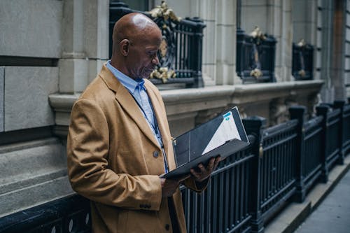 Experienced black lawyer reading documents on street