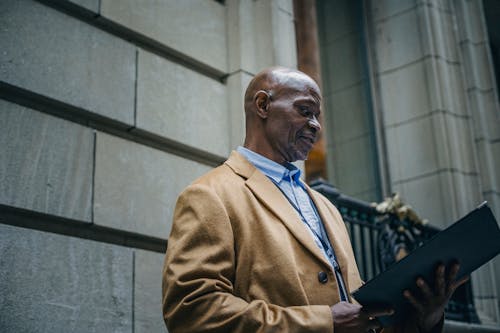 Grave Empresario Negro Leyendo Documentos En La Calle