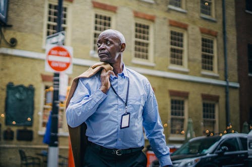 Serious black man crossing road on busy street