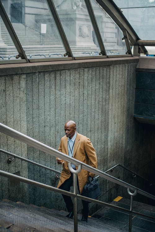 Black businessman going upstairs on metro staircase