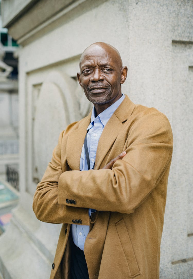 Stylish Confident Black Entrepreneur With Folded Arms On Street