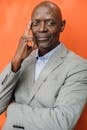 Intelligent black businessman in suit on orange background