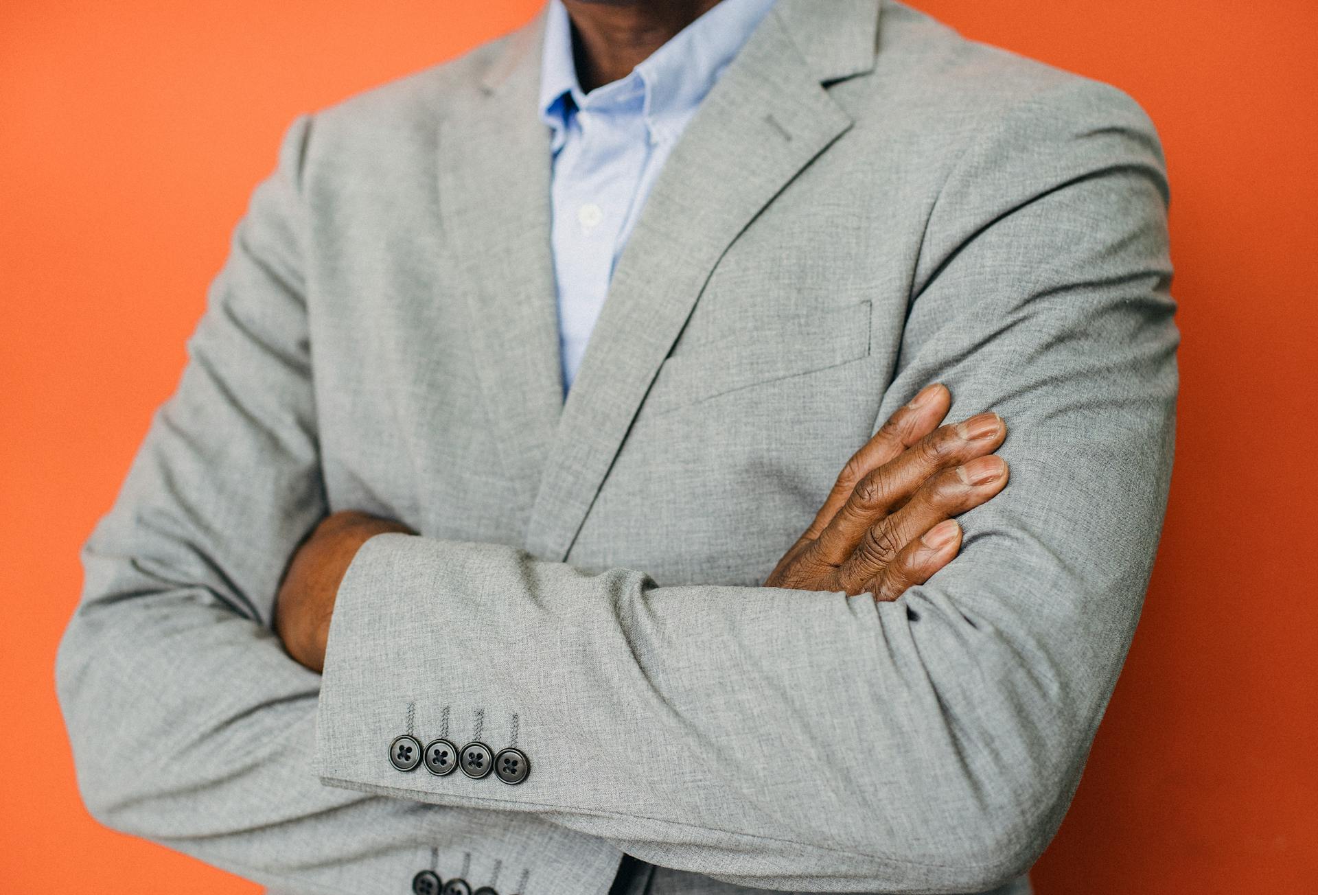 Crop self assured black male executive on orange background