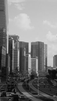 Black and white cityscape featuring high-rise buildings and busy roads, capturing urban life. - Fotografer Sidoarjo