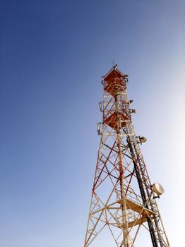 低角度镜头下的红白通信塔与清澈蓝天