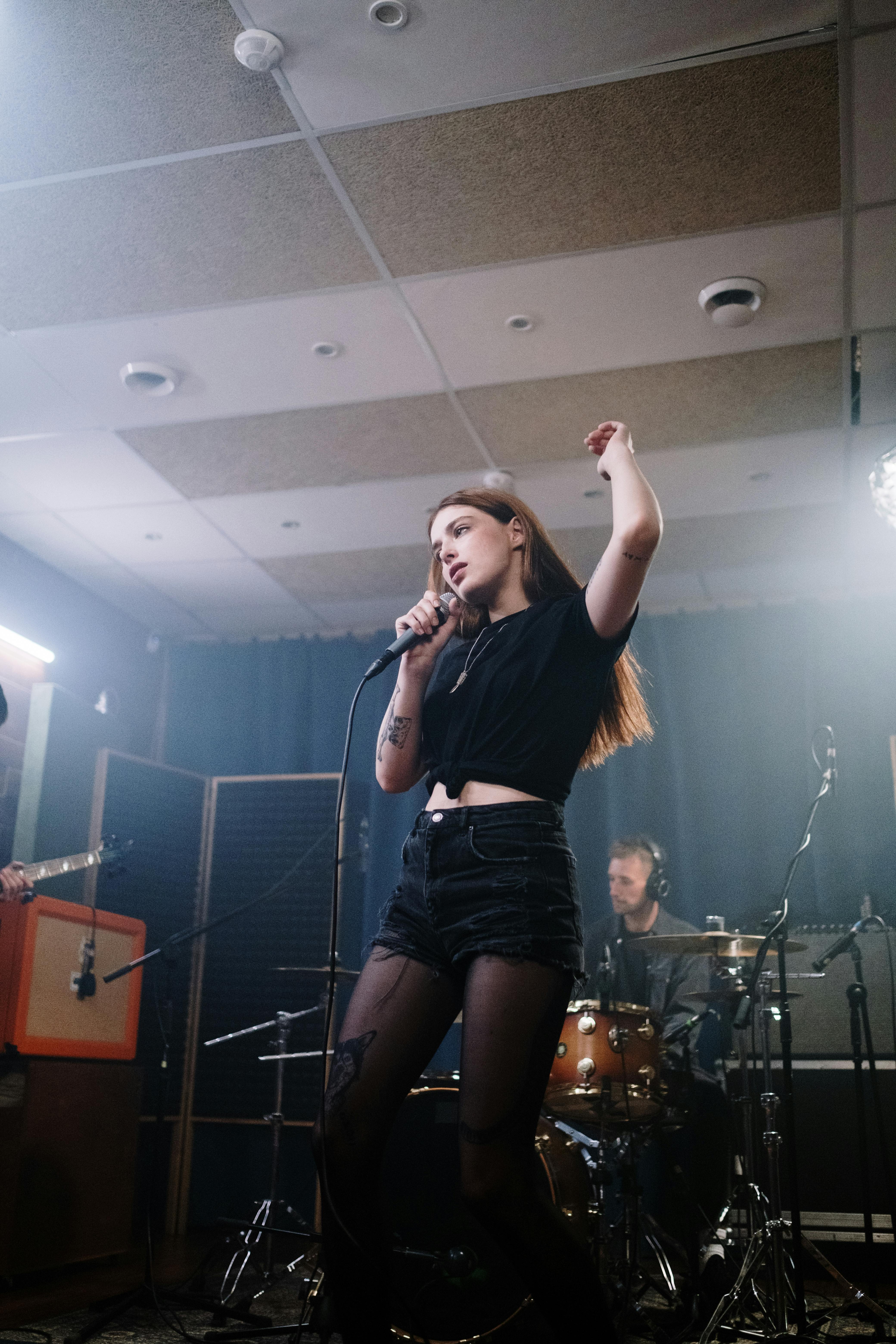 woman in black crop top singing on stage