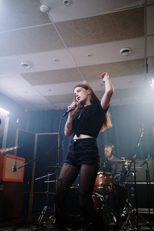 Free Woman in Black Crop Top Singing on Stage Stock Photo