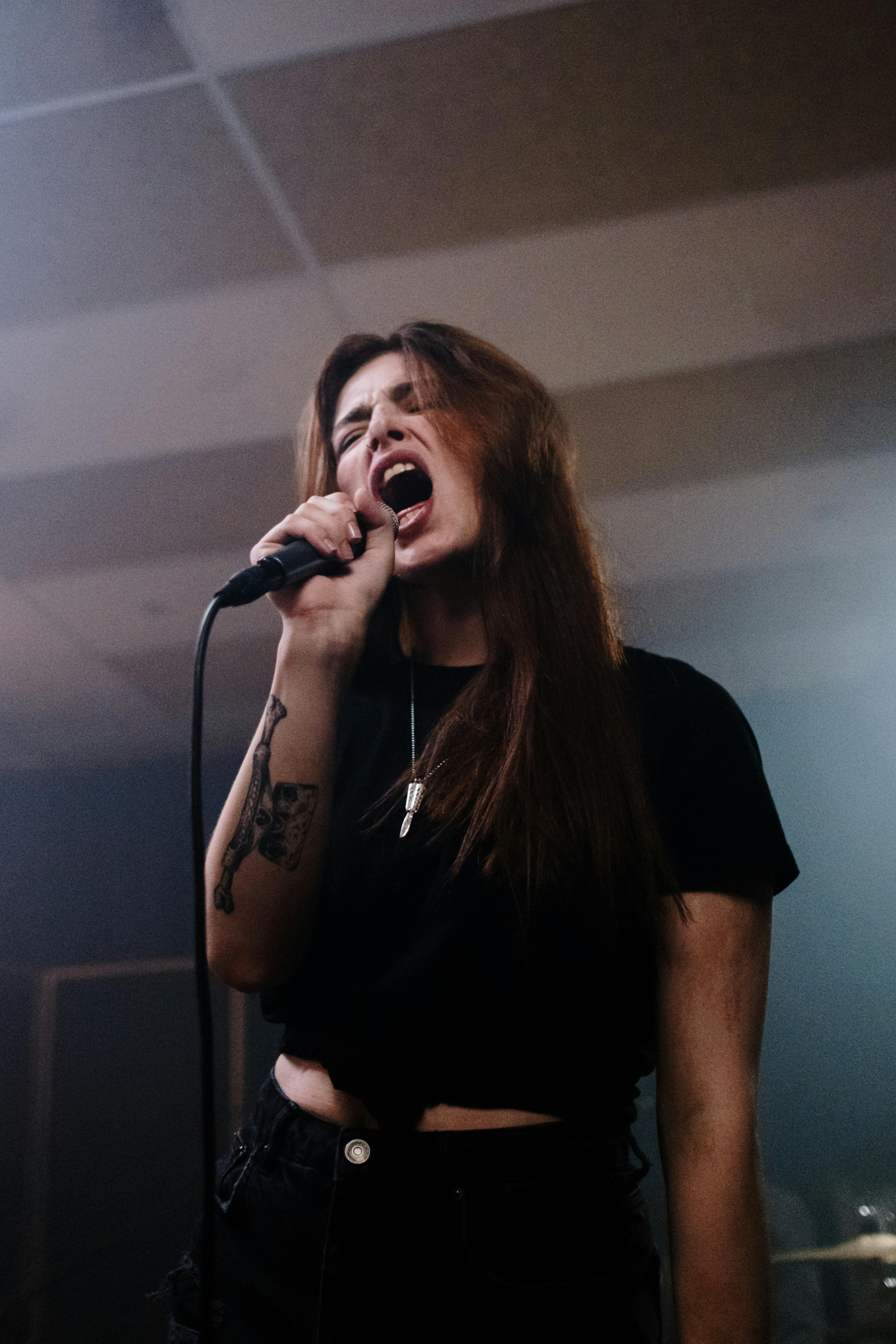 a woman holding a microphone while singing