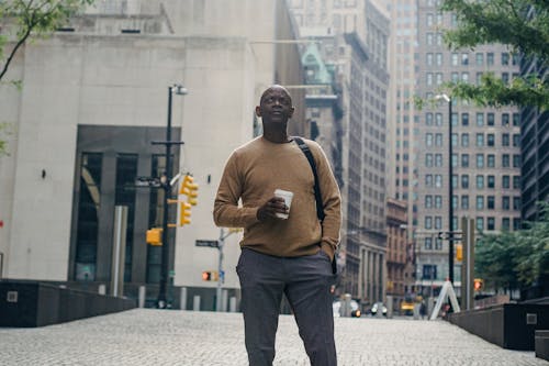 Thoughtful mature black man standing on street while sightseeing city