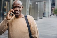 一名穿着休闲服装的中年黑人正在城市环境中打电话