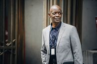 一位穿着西装的非裔美国职业男子自信地站在户外