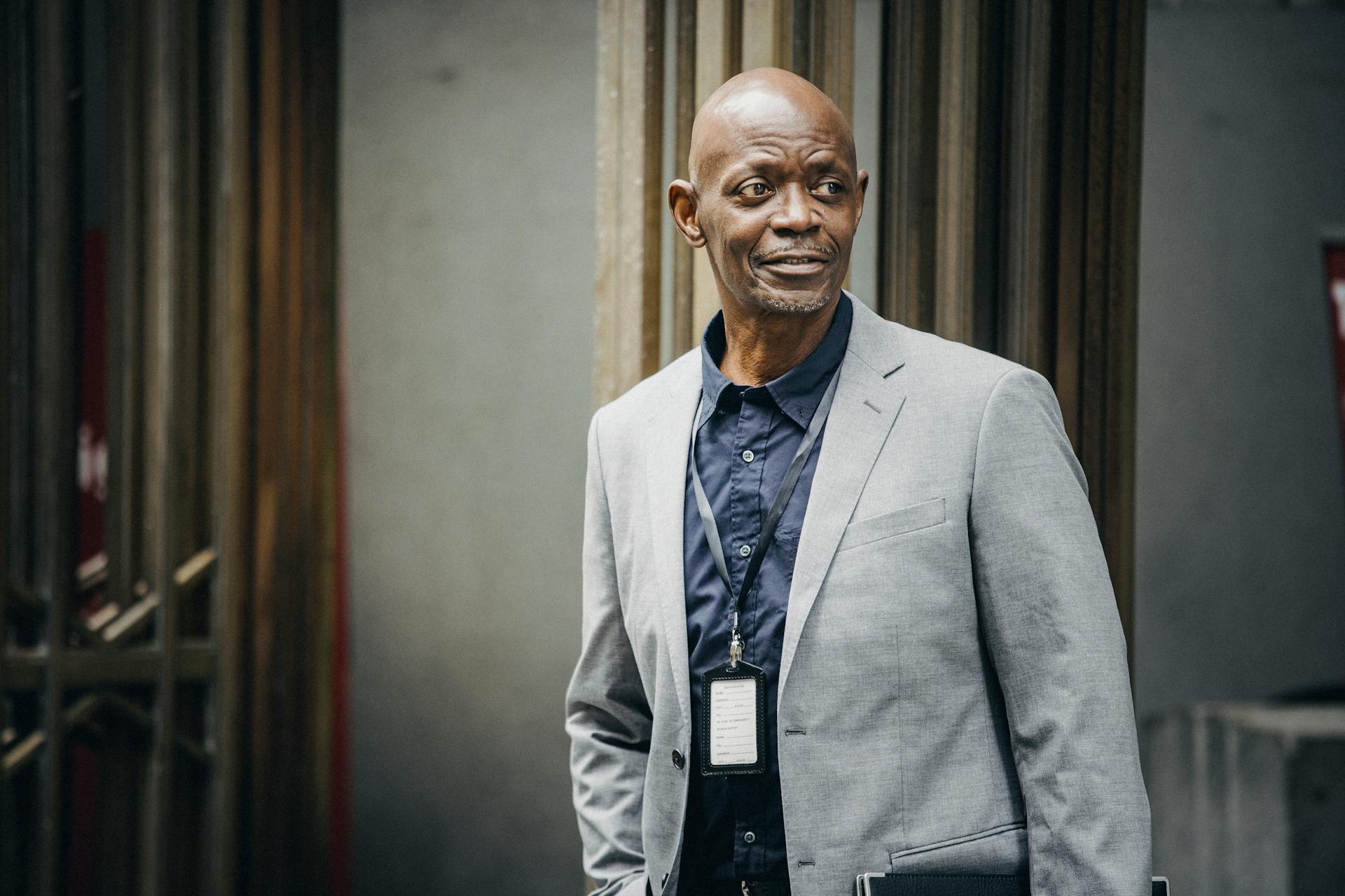 Professional African American man in a suit, standing confidently outdoors.