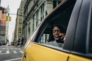 Man Sitting By The Window Of A Yellow Car