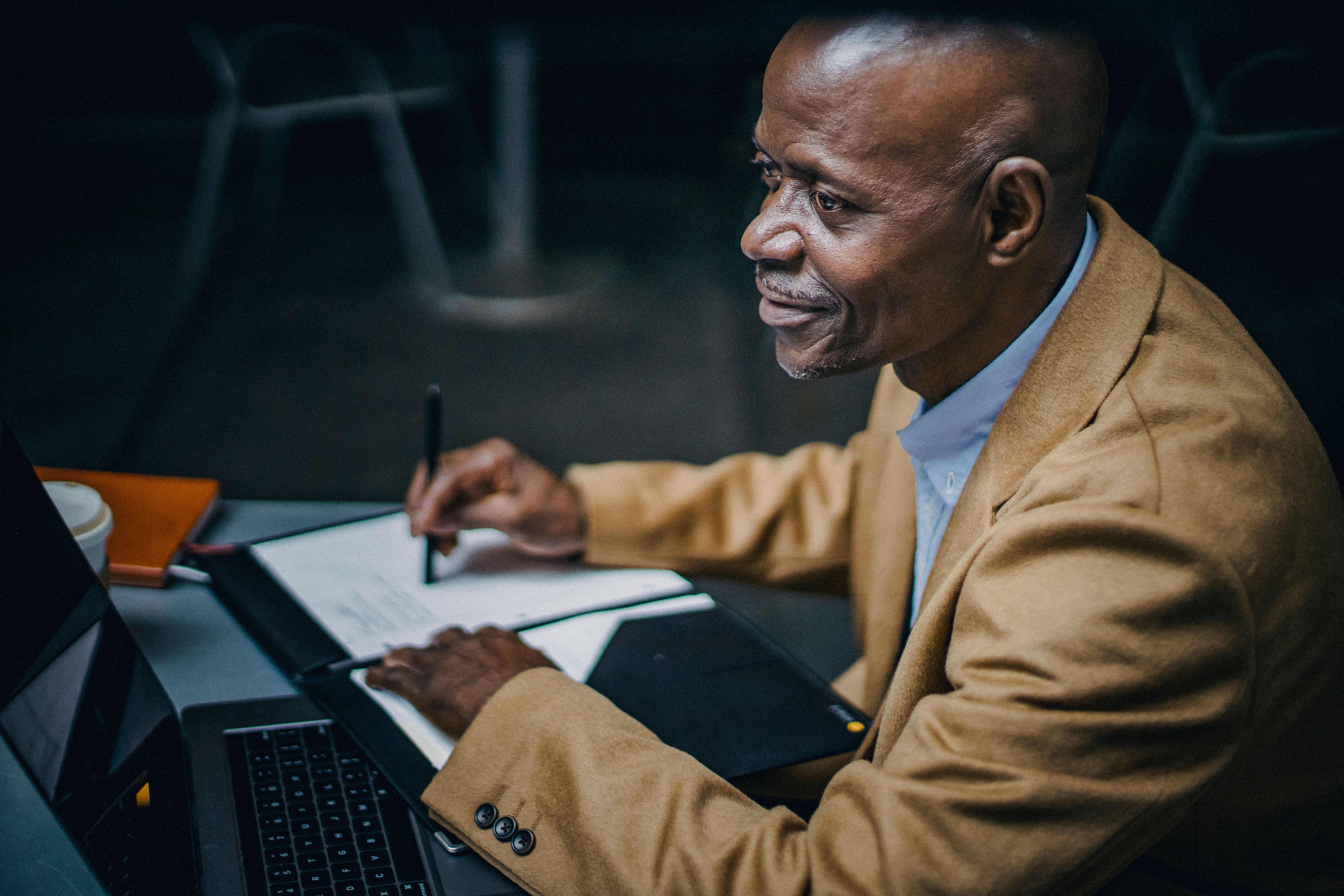Black self-employed entrepreneur working on a laptop and reviewing business documents