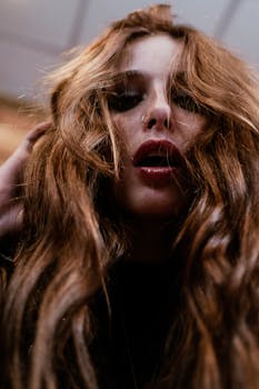 一个鼻穿孔、长发的女人的特写肖像，从低角度在室内拍摄