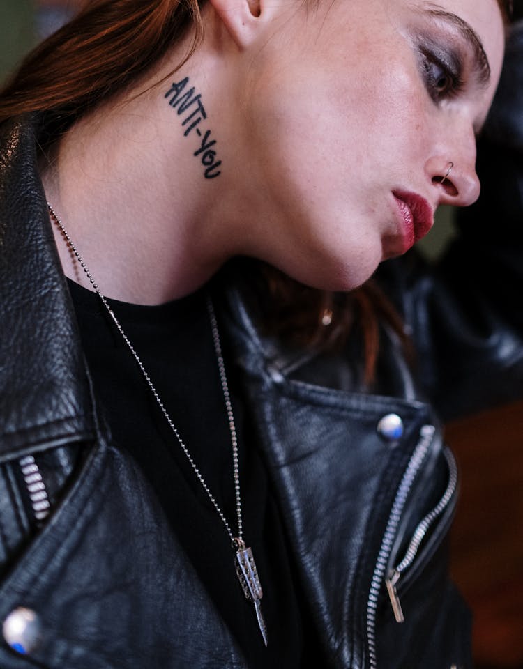 Woman In Black Leather Jacket With Tattoo On Neck 