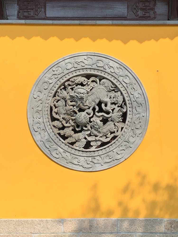 Sculpted Circular Design On A Yellow Wall