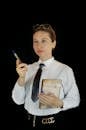 Focused businesswoman standing with diary in studio
