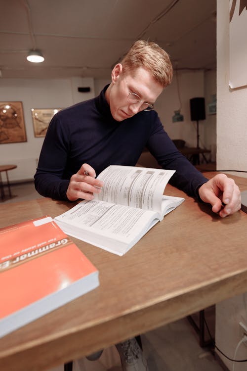 Man Studying on Wooden Table