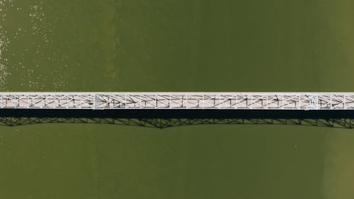 Free Aerial top view of modern motor bridge crossing vast rippling river on sunny day Stock Photo