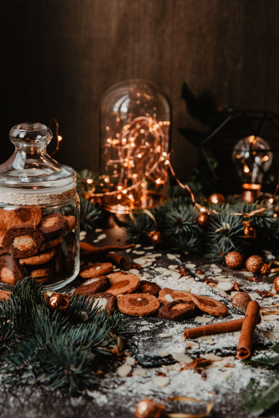 Spiced biscuits and warm fairy lights on a dark table, photo by Anna Peipina on Pexels