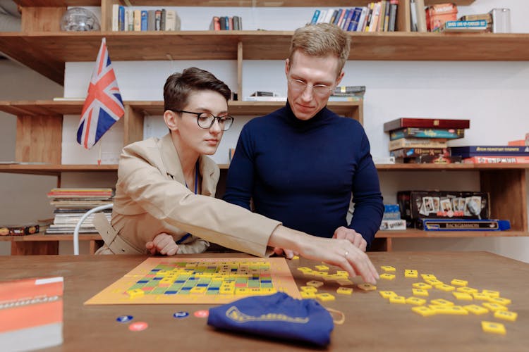 Man And Woman Playing Scrabble Inside The Library