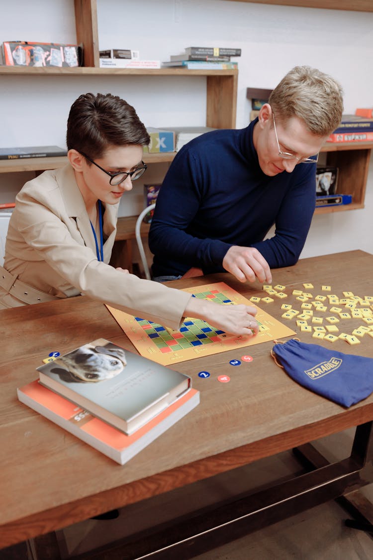 A Man And A Woman Playing Scrabble