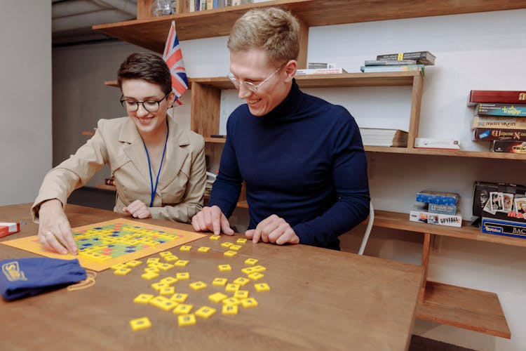 Man And Woman Playing Scrabble Inside The Library