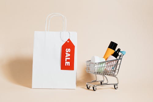 A White Paper Bag and Shopping Cart on Beige Background