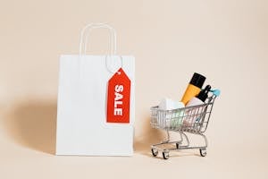 A White Paper Bag and Shopping Cart on Beige Background