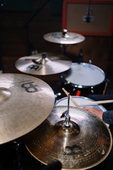 A vibrant close-up of a drummer playing a drum kit, highlighting cymbals and sticks.