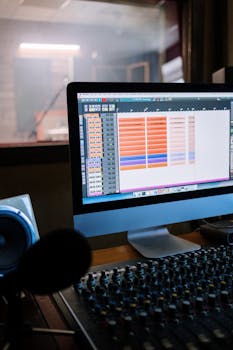 Modern recording studio with computer and mixing console, inside view.