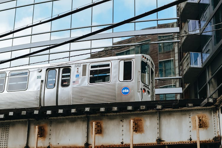 Old Train Going Near Modern Building