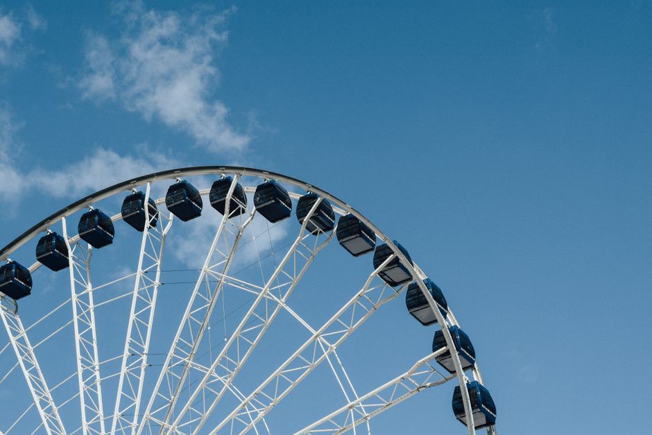 From below of contemporary observation wheel located in city against blue sky in daytime