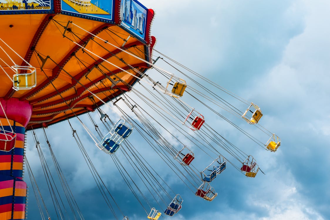 Free From below of colorful chain carousel located in amusement park in cloudy day Stock Photo