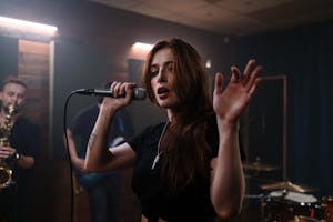 A Woman in Black Shirt Holding a Mic and Singing